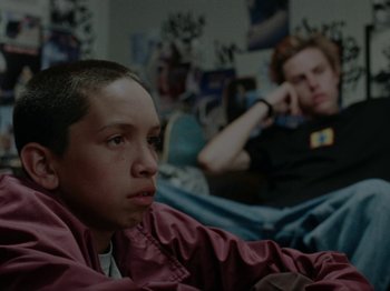 Movie still from “Mid90s” (2018), directed by Jonah Hill – Two young men sitting on a bed in front of a wall; Close Up shot, High angle