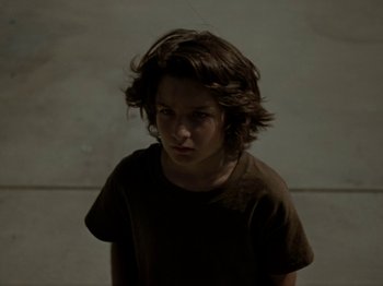Movie still from “Mid90s” (2018), directed by Jonah Hill – A young man with long hair is looking at the camera; Close Up shot, Low angle