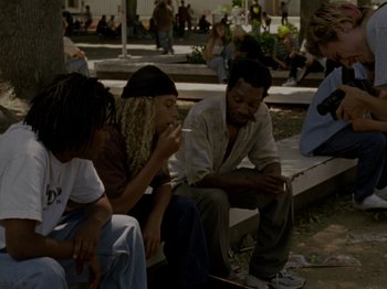 Movie still from “Mid90s” (2018), directed by Jonah Hill – A group of young people sitting on a park bench; Wide shot, High angle