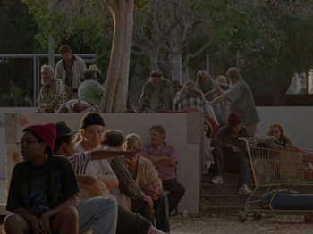 Movie still from “Mid90s” (2018), directed by Jonah Hill – A group of people sitting on the ground in front of a tree; Wide shot, High angle