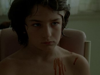 Movie still from “Mid90s” (2018), directed by Jonah Hill – A young boy with blood on his chest and chest; Close Up shot, Low angle