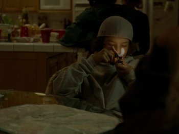 Movie still from “Mid90s” (2018), directed by Jonah Hill – A young child sitting at a table eating food; Medium shot, High angle