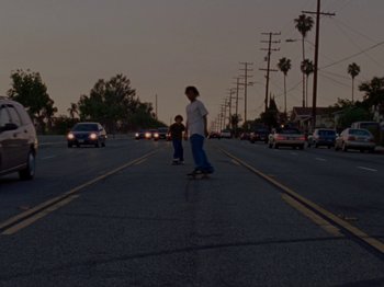 Movie still from “Mid90s” (2018), directed by Jonah Hill – Two skateboarders on the street at night with cars on the road; Wide shot, Low angle