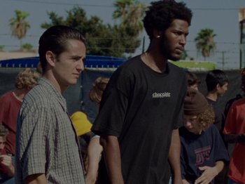 Movie still from “Mid90s” (2018), directed by Jonah Hill – Two young men standing next to each other in front of a group of onlookers; Medium shot, Low angle