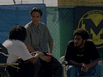 Movie still from “Mid90s” (2018), directed by Jonah Hill – A group of young men sitting on a bench; Medium shot, High angle