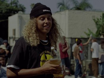 Movie still from “Mid90s” (2018), directed by Jonah Hill – A person holding a bottle of beer in their hand; Medium shot, Over the shoulder angle