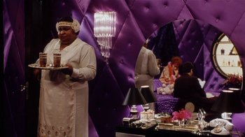 Movie still from “Bullets Over Broadway” (1994), directed by Woody Allen – A woman holding a tray in front of a purple wall; Medium shot, Over the shoulder angle