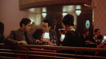 Movie still from “Bullets Over Broadway” (1994), directed by Woody Allen – A group of people sitting at a table in front of a mirror; Medium shot, Over the shoulder angle