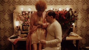 Movie still from “Bullets Over Broadway” (1994), directed by Woody Allen – A man and a woman are sitting in a room; Medium shot, High angle