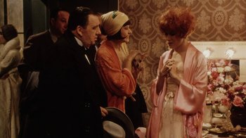 Movie still from “Bullets Over Broadway” (1994), directed by Woody Allen – A group of people standing next to each other in a room; Medium shot, High angle