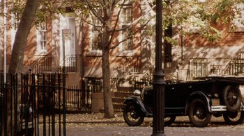 Movie still from “Bullets Over Broadway” (1994), directed by Woody Allen – An antique car parked on the side of the street; Extreme Wide shot, High angle