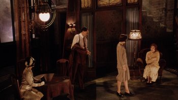 Movie still from “Bullets Over Broadway” (1994), directed by Woody Allen – A man and a woman standing in front of a lamp; Wide shot, High angle