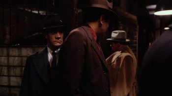 Movie still from “Bullets Over Broadway” (1994), directed by Woody Allen – A group of men standing next to each other wearing hats; Medium shot, Over the shoulder angle