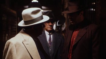 Movie still from “Bullets Over Broadway” (1994), directed by Woody Allen – Two men in suits and hats standing next to each other; Medium shot, Over the shoulder angle
