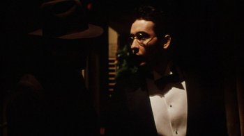 Movie still from “Bullets Over Broadway” (1994), directed by Woody Allen – A man in a tuxedo is looking at the camera; Close Up shot, Over the shoulder angle