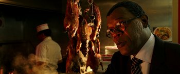 Movie still from “xXx: Return of Xander Cage” (2017), directed by D.J. Caruso – A man sitting in front of a bunch of meat hanging from hooks; Close Up shot, Low angle