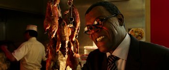 Movie still from “xXx: Return of Xander Cage” (2017), directed by D.J. Caruso – A man in a suit and tie next to a bunch of meat; Close Up shot, Over the shoulder angle