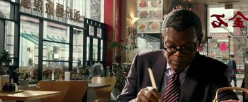 Movie still from “xXx: Return of Xander Cage” (2017), directed by D.J. Caruso – An older man sitting at a table writing on a piece of paper; Close Up shot, Over the shoulder angle