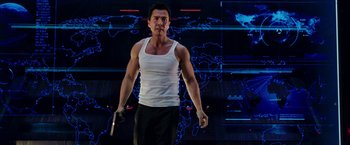 Movie still from “xXx: Return of Xander Cage” (2017), directed by D.J. Caruso – A man in a white tank top holding a cell phone in his hand; Medium shot, Low angle