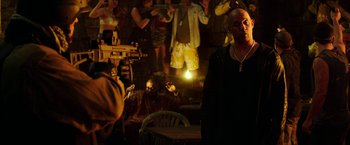 Movie still from “xXx: Return of Xander Cage” (2017), directed by D.J. Caruso – A man standing in front of a group of people in a room; Medium shot, Over the shoulder angle