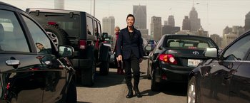 Movie still from “xXx: Return of Xander Cage” (2017), directed by D.J. Caruso – A man in a black suit walking in the middle of a street; Wide shot, Over the shoulder angle