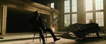 Movie still from “xXx: Return of Xander Cage” (2017), directed by D.J. Caruso – A man sitting on a chair in a room; Wide shot, Low angle