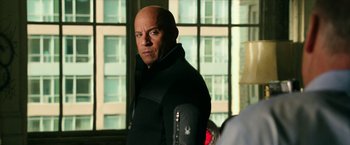Movie still from “xXx: Return of Xander Cage” (2017), directed by D.J. Caruso – A bald man in a black jacket standing in front of a window; Close Up shot, Over the shoulder angle