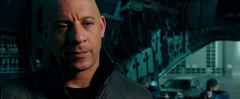 Movie still from “xXx: Return of Xander Cage” (2017), directed by D.J. Caruso – A man with a bald head is looking at the camera; Close Up shot, Over the shoulder angle