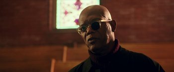 Movie still from “xXx: Return of Xander Cage” (2017), directed by D.J. Caruso – An older man wearing sunglasses in front of a stained glass window; Close Up shot, Low angle