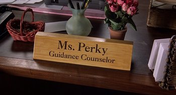 Movie still from “10 Things I Hate About You” (1999), directed by Gil Junger – A wooden sign that says " ms; Extreme Close Up shot, High angle