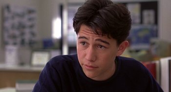 Movie still from “10 Things I Hate About You” (1999), directed by Gil Junger – A young man looking at the camera while sitting down; Close Up shot, High angle