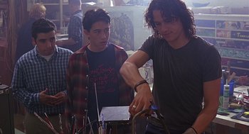 Movie still from “10 Things I Hate About You” (1999), directed by Gil Junger – A group of young men standing next to each other in a room; Medium shot, Over the shoulder angle