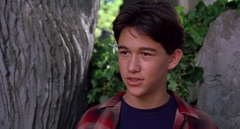 Movie still from “10 Things I Hate About You” (1999), directed by Gil Junger – A young man in a red and black plaid shirt looks to his left; Close Up shot, High angle