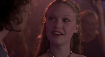 Movie still from “10 Things I Hate About You” (1999), directed by Gil Junger – A young girl wearing a pearl necklace looking up; Close Up shot, Over the shoulder angle
