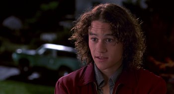 Movie still from “10 Things I Hate About You” (1999), directed by Gil Junger – A young man with long hair and a red jacket; Close Up shot, High angle