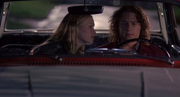 Movie still from “10 Things I Hate About You” (1999), directed by Gil Junger – A man and a woman sitting in a red car; Medium shot, Over the shoulder angle