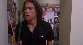 Movie still from “10 Things I Hate About You” (1999), directed by Gil Junger – A man with long curly hair is standing in a room; Close Up shot, Low angle
