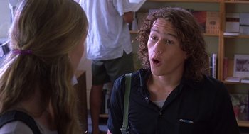 Movie still from “10 Things I Hate About You” (1999), directed by Gil Junger – A man with long curly hair talking to a woman; Close Up shot, Over the shoulder angle