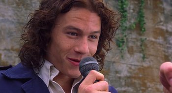 Movie still from “10 Things I Hate About You” (1999), directed by Gil Junger – A man holding a microphone up to his mouth; Close Up shot, High angle