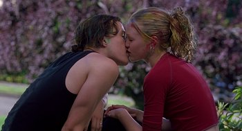 Movie still from “10 Things I Hate About You” (1999), directed by Gil Junger – Two people kissing each other in a park; Medium shot, Low angle