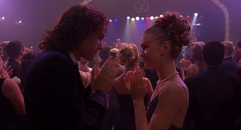 Movie still from “10 Things I Hate About You” (1999), directed by Gil Junger – A man and a woman dancing together in front of a crowd of onlookers; Medium shot, Over the shoulder angle