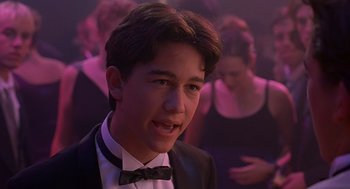 Movie still from “10 Things I Hate About You” (1999), directed by Gil Junger – A young man in a suit and bow tie; Close Up shot, Over the shoulder angle