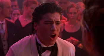 Movie still from “10 Things I Hate About You” (1999), directed by Gil Junger – A man in a white suit and black bow tie; Close Up shot, Low angle