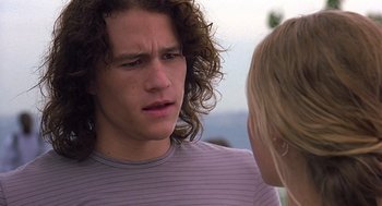 Movie still from “10 Things I Hate About You” (1999), directed by Gil Junger – A man with long curly hair is talking to a woman; Close Up shot, Over the shoulder angle