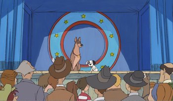 Movie still from “101 Dalmatians 2: Patch's London Adventure” (2002), directed by Brian Smith – A dog and a dalmatian are on stage in front of an audience; Wide shot, High angle