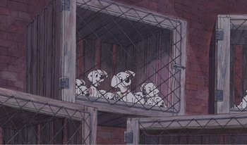 Movie still from “101 Dalmatians 2: Patch's London Adventure” (2002), directed by Brian Smith – A group of dogs sitting in a caged in area; Wide shot, Low angle