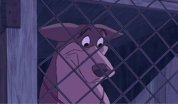 Movie still from “101 Dalmatians 2: Patch's London Adventure” (2002), directed by Brian Smith – A dog looking through the bars of a cage; Close Up shot, Low angle