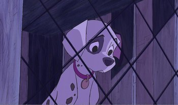 Movie still from “101 Dalmatians 2: Patch's London Adventure” (2002), directed by Brian Smith – A cartoon of a dalmatian dog looking through the bars of a cage; Medium shot, High angle
