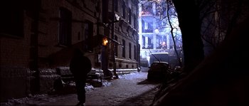 Movie still from “12” (2007), directed by Nikita Mikhalkov – A person walking down a street at night; Extreme Wide shot, High angle