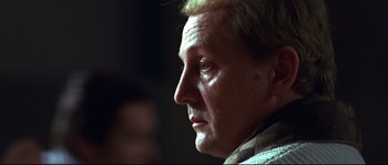Movie still from “12” (2007), directed by Nikita Mikhalkov – An older man looking into the distance with a serious look; Close Up shot, Over the shoulder angle